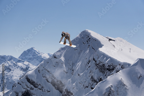Cuadros en Lienzo Corredor de snowboard que salta sobre las montañas