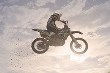 Silhouetted Young Male Motocross Racer Jumping Mid Air