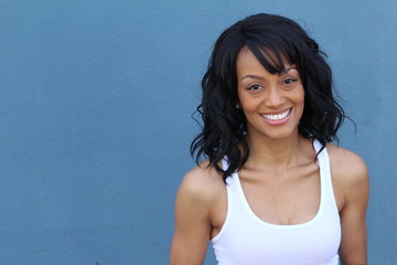 Close up beauty portrait of a young and attractive African American black woman with perfect skin, softly smiling. Health and beauty outdoors lifestyle with copy space.