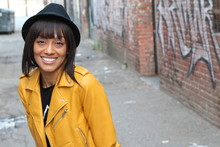 Lifestyle Photo Shoot Portrait Of Cool Trendy Stylish Sexy Hipster African Ethnic Girl With Septum Piercing Ring. Wearing Yellow Leather Jacket And A Hat With Copy Space. 