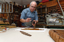 Senior Man Repairing Fragile Book Spine In Traditional Bookbinding Workshop
