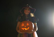 © Connect Images - Portrait of girl wearing halloween witch costume holding pumpkin
