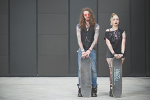 Portrait Of Punk Hippy Couple Holding Skateboards