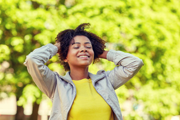 Wall Mural - happy african american young woman in summer park