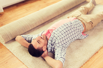 happy man lying carpet or rug at home