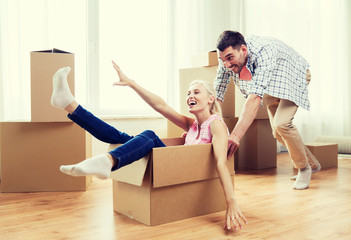 Poster - couple with cardboard boxes having fun at new home