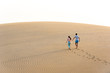© Simon Dannhauer - Couple walking together on sand dune