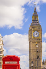 Wall Mural - Iconic Red British telephone box with Big Ben on a sunny afternoon with blue sky and clouds - London, UK