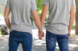 Homosexual couple outside, hold hands, back view