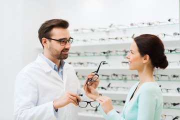 Canvas Print - woman and optician showing glasses at optics store