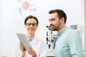 Canvas Print - optician with tablet pc and patient at eye clinic