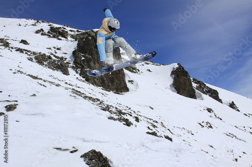 Cuadros en Lienzo Corredor de snowboard que salta en las montañas de invierno