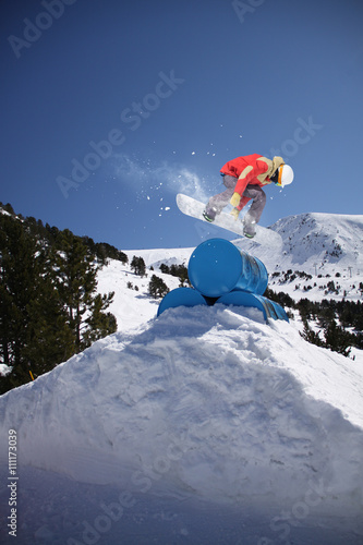 Fotografía Corredor de snowboard que salta en las montañas de invierno