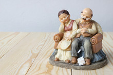 Lovely Grandparent Dolls Sleeping With A Book On Wood Background