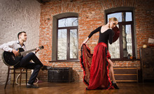 Young Woman Dancing Flamenco And A Man Playing The Guitar