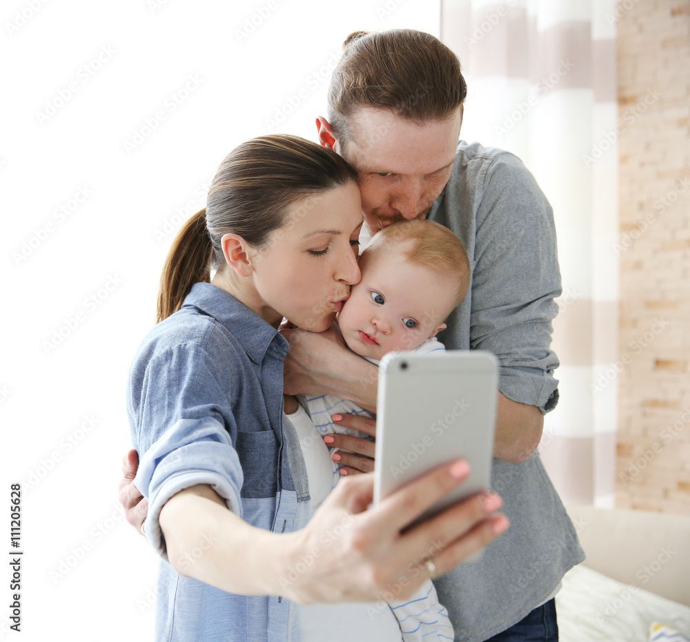 Happy couple taking a selfie with baby, close up