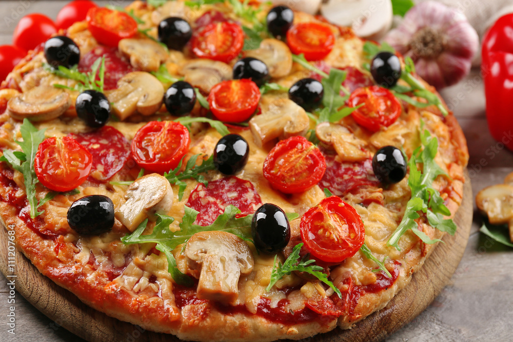 Delicious tasty pizza with ingredients on wooden table