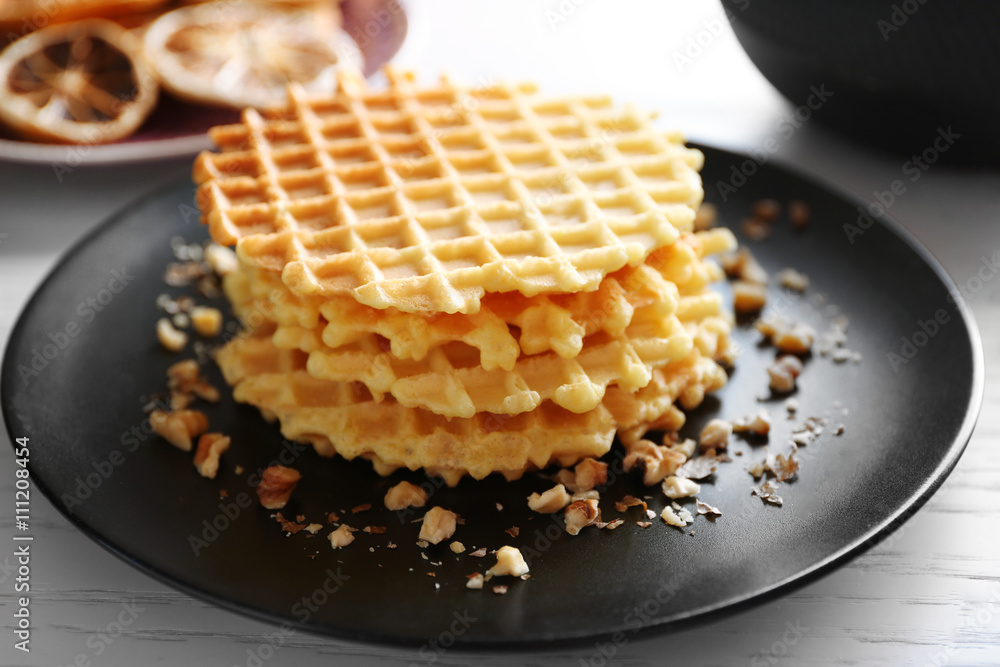 Fresh waffles with honey and dried oranges on wooden background