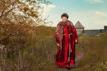 Vintage North Grandmother In Red Dress And Shawl On The Wooden F
