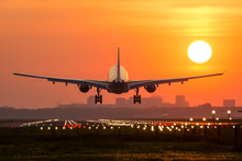 Passenger Plane Is Landing During A Wonderful Sunrise.
