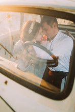 Portrait Of Young Girl With Floral Headband And Handsome Man Sitting In Vintage Car Smiling Face-to-face
