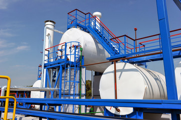 Wall Mural - White fuel tanks and color gas pipes in natural gas treatment plant in bright sunny summer day