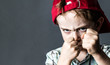 threatening boy with freckles and red hat back looking violent