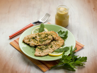 Wall Mural - breaded cutlet with herbs and mustard, selective focus