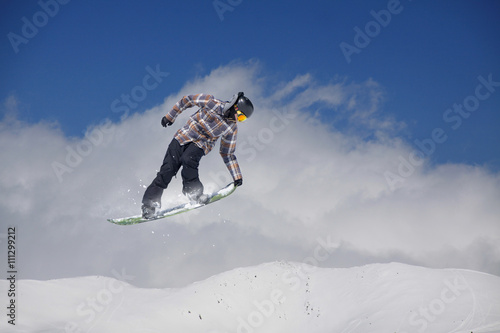 Cuadros en Lienzo Corredor de snowboard que salta sobre las montañas