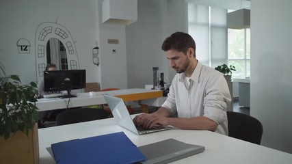 Poster -  Worker using computer. Businessman typing on laptop. Young mixed race employee concentrated at the work. 