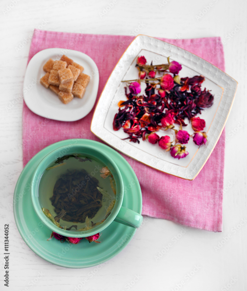 Cup of tea with aromatic dry tea on wooden background