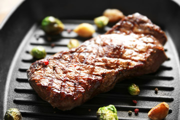 Sticker - Grilled steak with garlic and Brussels sprouts on grill pan, closeup