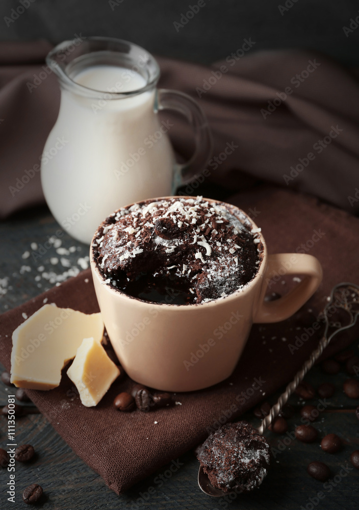 Chocolate fondant cake in cup on wooden table closeup