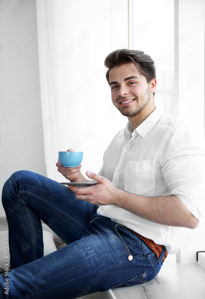 Handsome man drinking coffee in the room