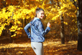 Fototapeta Przestrzenne - Young beautiful woman jogging in autumn park