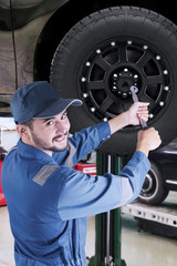 Arabic mechanic replacing a car wheel