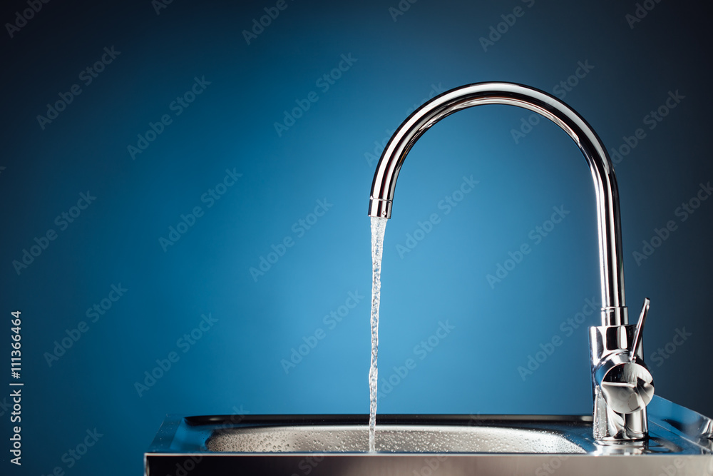 mixer tap with flowing water, blue background - obrazy, fototapety, plakaty 