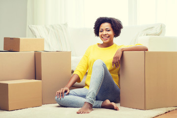 Wall Mural - happy african woman with cardboard boxes at home