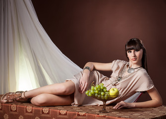 Wall Mural - Girl in Greek costume on a brown background in studio