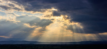 Stormy Clouds With Radiating Sunbeams Above Countryside.