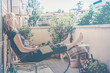 lazy woman relaxing sitting on balcony falling asleep with a book in hand - vintage matte look