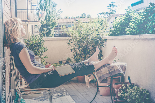 Fotomural lazy woman relaxing sitting on balcony falling asleep with a book in hand - vint