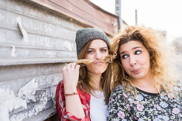 Two young curly and straight blonde hair woman