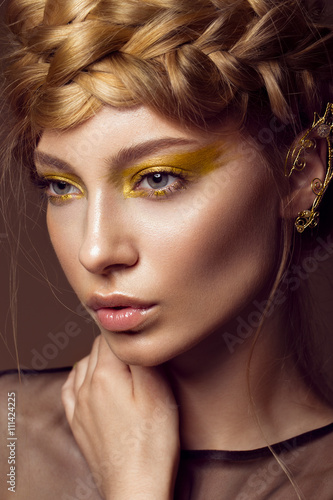 Fotografie, Obraz Beautiful girl in a gold dress with creative makeup and braids on her head