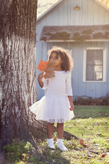 Wall Mural - Kid toddler girl with autumn leaf playing outdoor