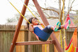 Kid toddler girl swinging on a playground swing