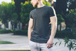 Photo Bearded Muscular Man Wearing Black Empty t-shirt and shorts in summer holiday. Green City Garden Park Background. Front view. Horizontal Mockup.