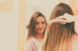 © Voyagerix - Woman combing her long hair in bathroom