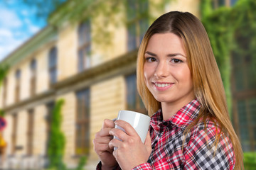 Portrait of a young woman with cup of tea or coffee