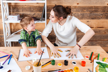 Wall Mural - Boy and mother making prints of painted hands on paper